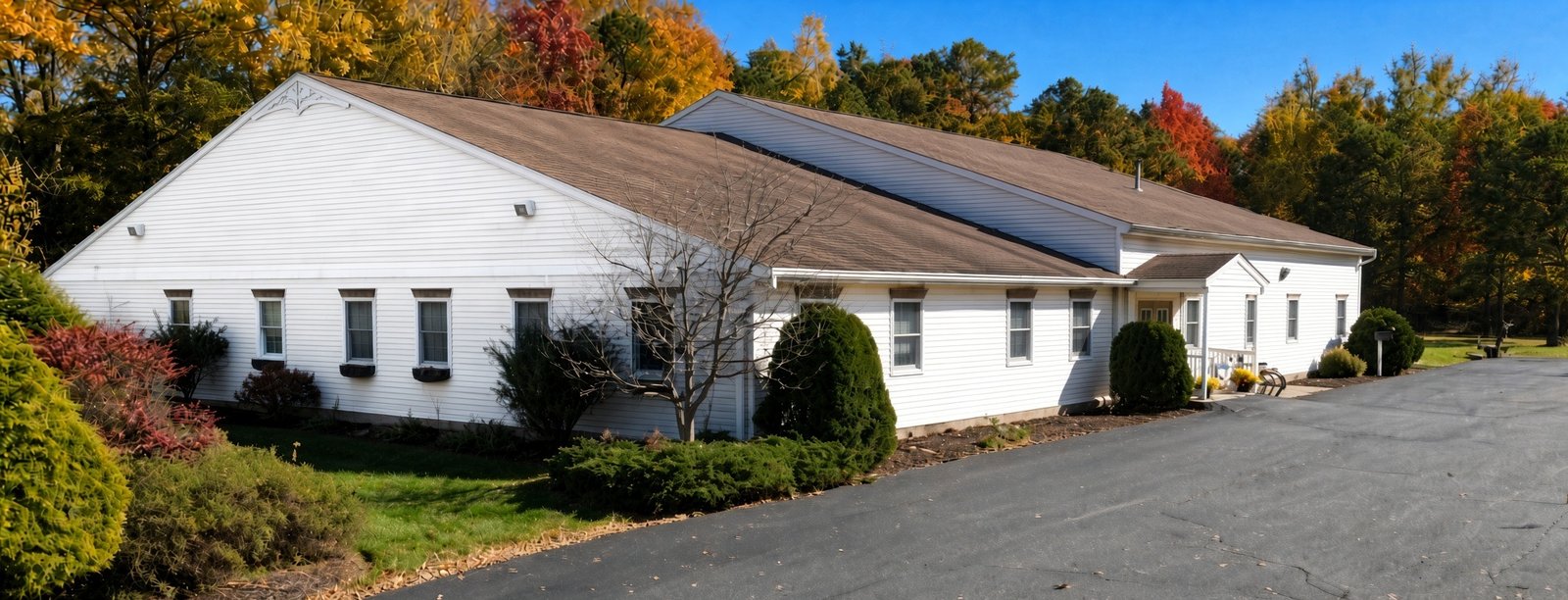 The Corrigan House, a white one-story building among autumn trees